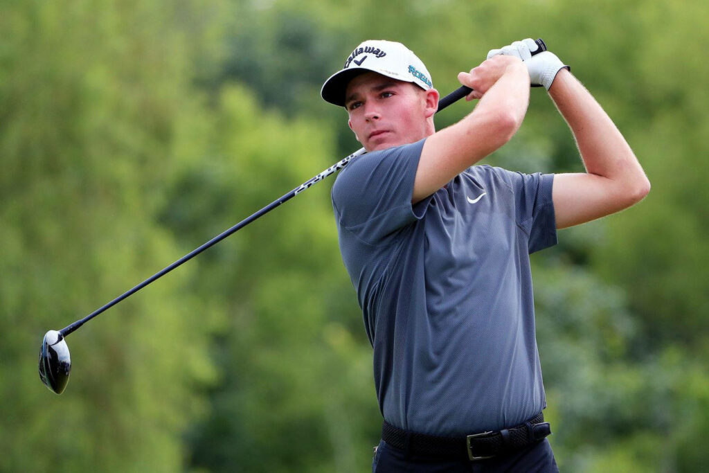 Aaron Wise golf swing follow through on lush green course professional golfer action shot Wallpaper