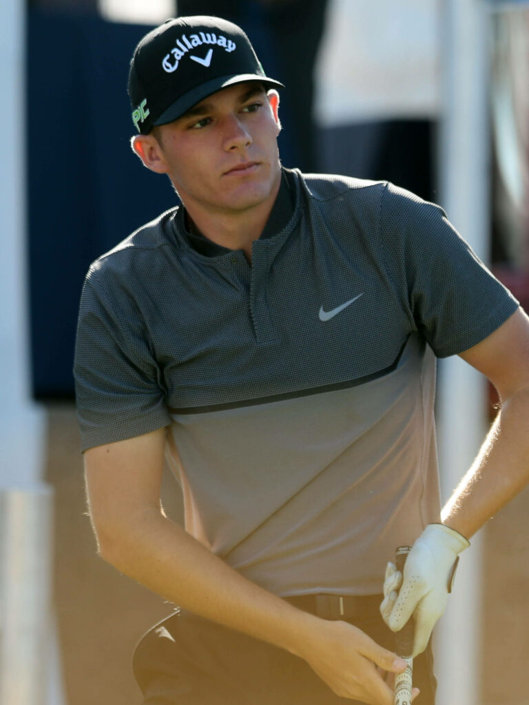 Golfer Aaron Wise in Nike shirt and Callaway cap focusing on golf shot on course wallpaper