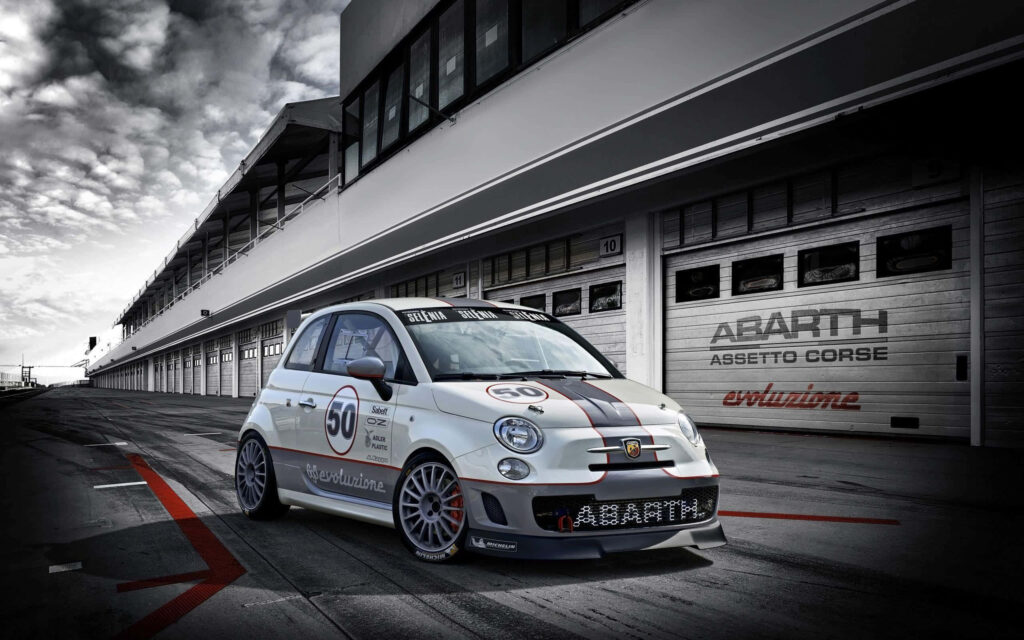 Abarth 695 racing past pit lane showcasing dynamic performance car in high detail wallpaper