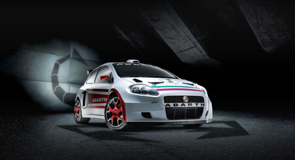 Abarth racing car in action with bold decals and red accents on dynamic wallpaper background