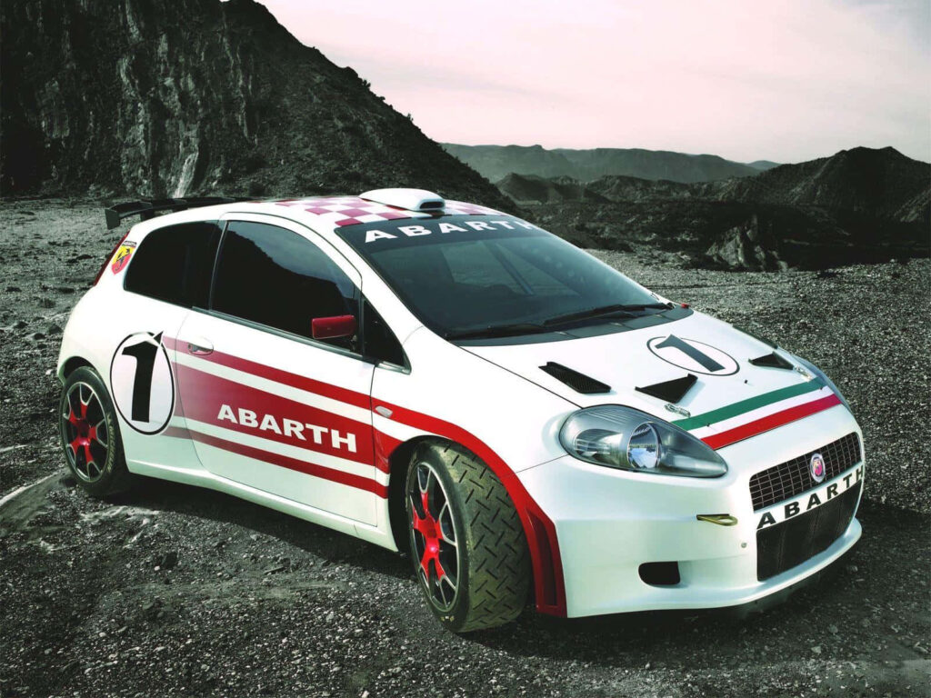 Abarth sports car on rugged mountain road with sleek racing livery vibrant dynamic design wallpaper