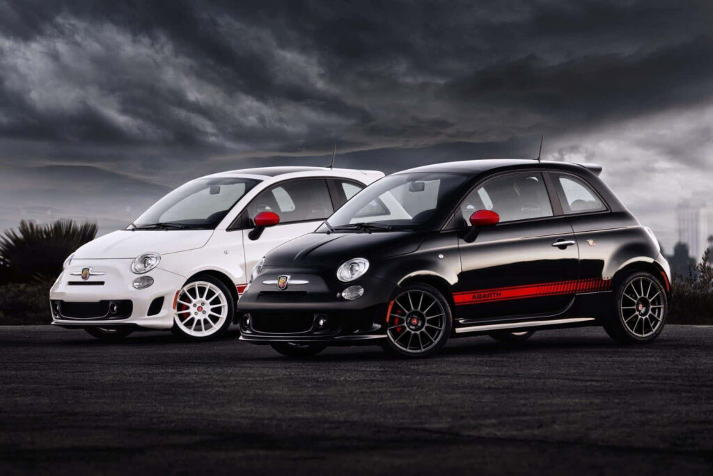 Two Abarth cars with sporty design and racing accents against a dramatic cloudy backdrop wallpaper