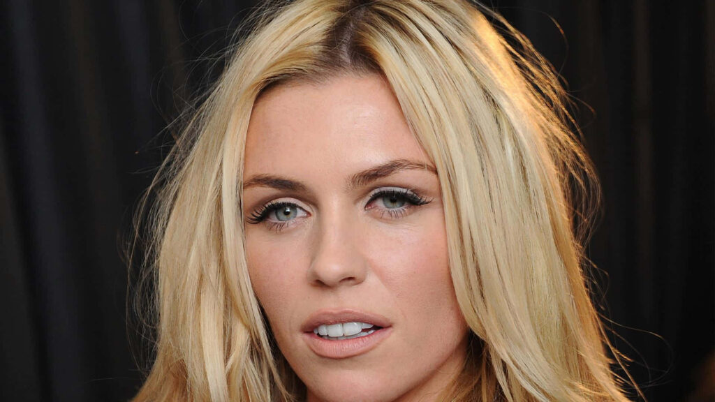 Close-up portrait of Abbey Clancy with blonde hair and natural makeup on dark background wallpaper