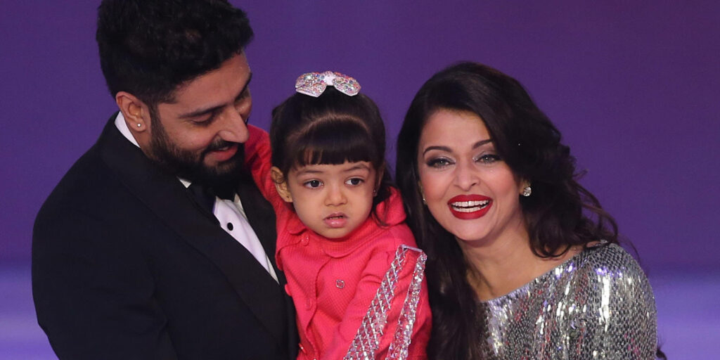 Abhishek Bachchan smiling warmly with daughter in heartwarming family wallpaper background