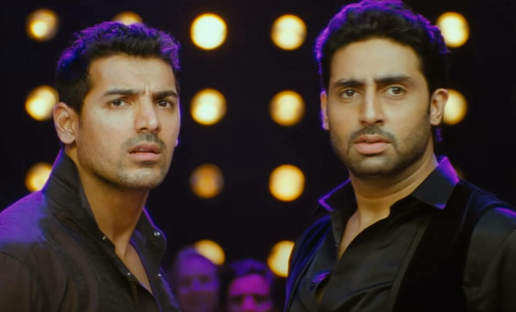 Abhishek Bachchan and John Abraham posing together under dramatic stage lights wallpaper background
