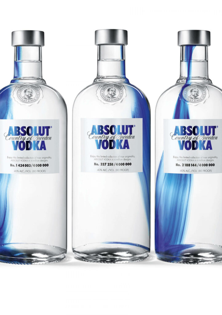 Three Absolut Vodka bottles with blue accents displayed on a clean white wallpaper background