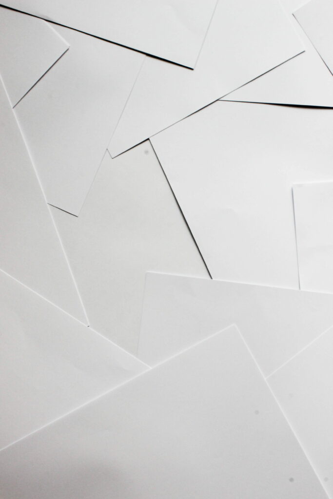 Minimalist abstract pattern of overlapping white A4 paper with sharp shadows for modern wallpaper
