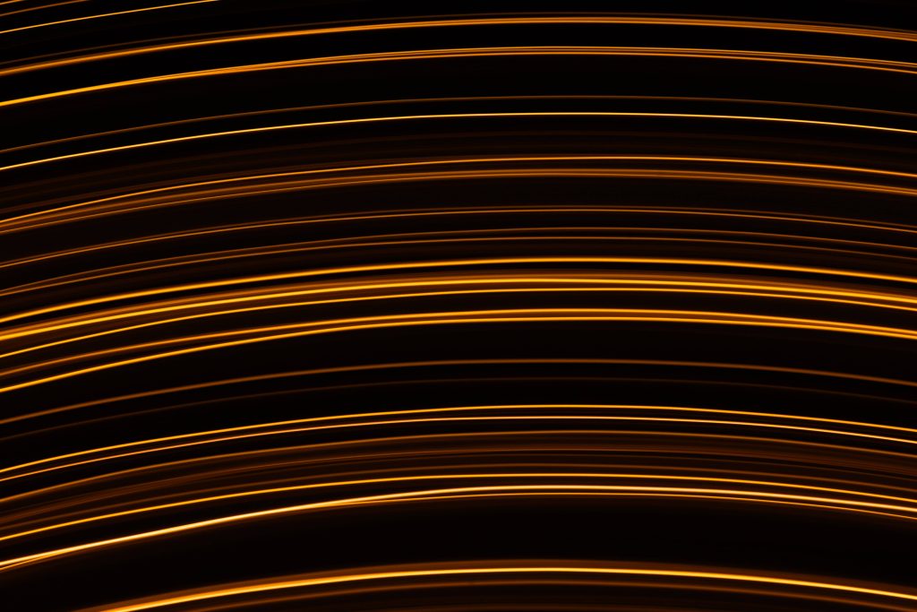 Abstract neon orange striped light trails on black background modern dynamic wallpaper background