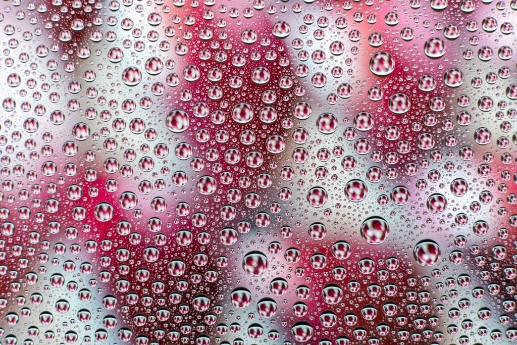 Stunning Close-Up of Water Drops on Smooth Red and White Background Wallpaper