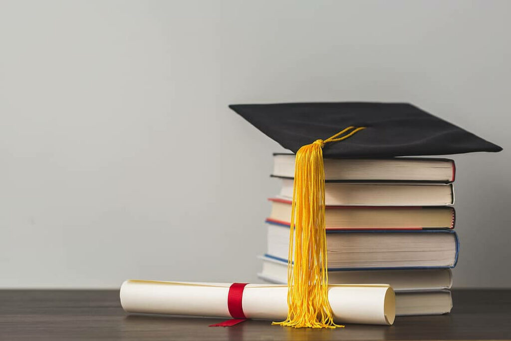 The Pathway to Achievement: A Motivational Education Background with a Symbolic Stack of Books and Educational Accolades Wallpaper
