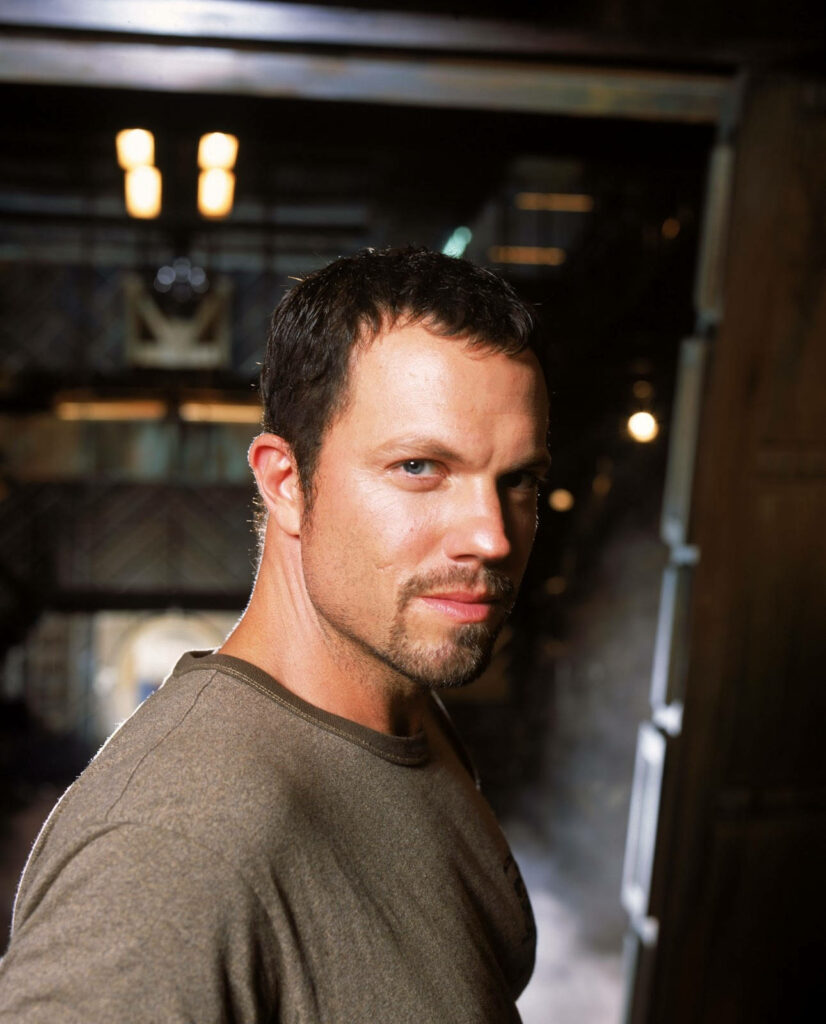 Adam Baldwin confident intense gaze dimly lit background wallpaper portrait close up