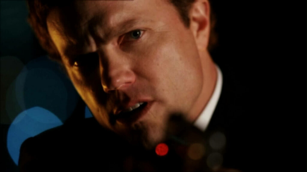 Adam Baldwin aiming gun with intense focus creating dramatic suspenseful wallpaper background