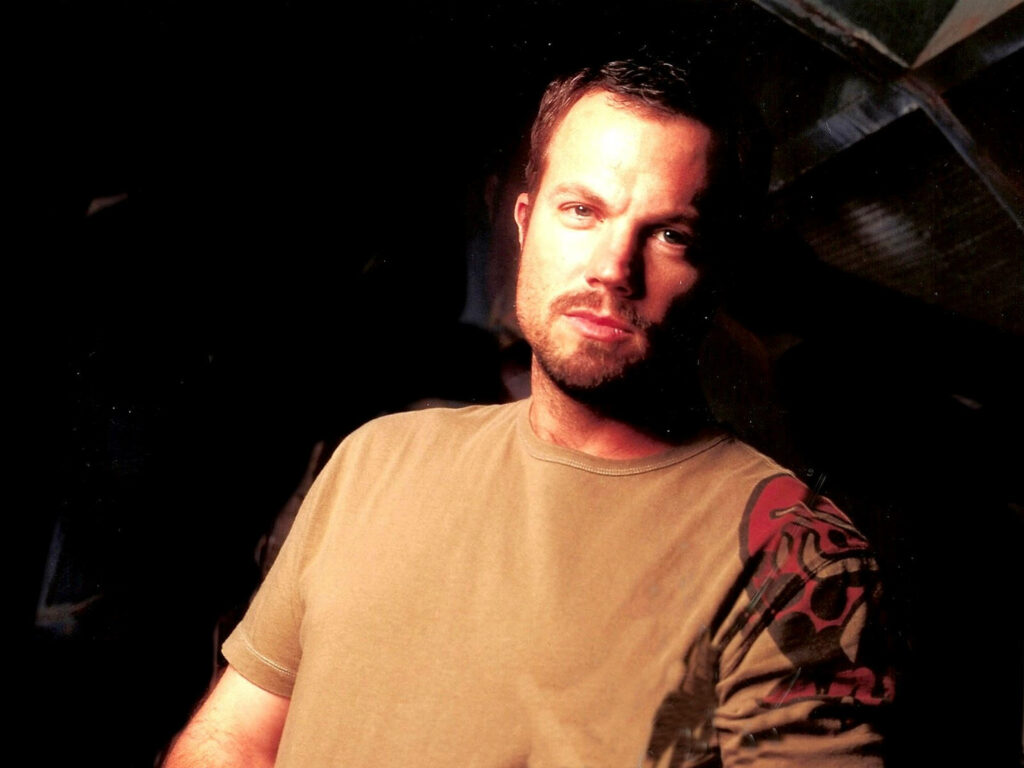 Adam Baldwin confident pose dark background warm lighting intense expression casual style wallpaper