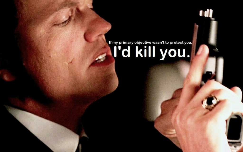 Adam Baldwin as Casey examining gun with bold protective quote wallpaper background image