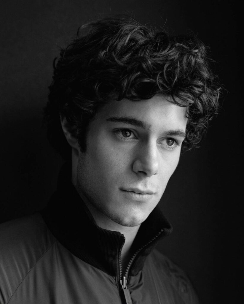 Black and white wallpaper of Adam Brody contemplative with dramatic lighting on dark background