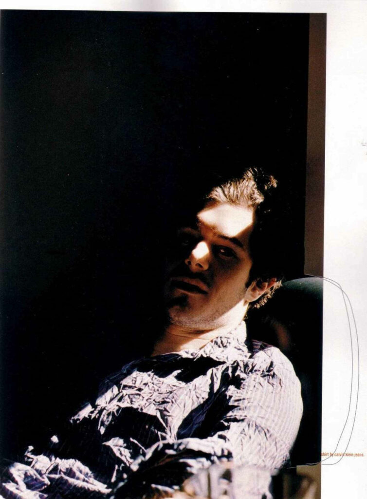 Adam Brody portrait with dramatic lighting thoughtful expression textured shirt artistic wallpaper