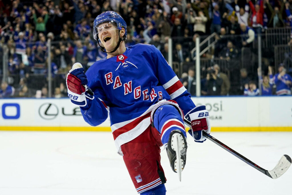 Adam Fox New York Rangers celebrates game-winning goal on ice with cheering fans wallpaper background