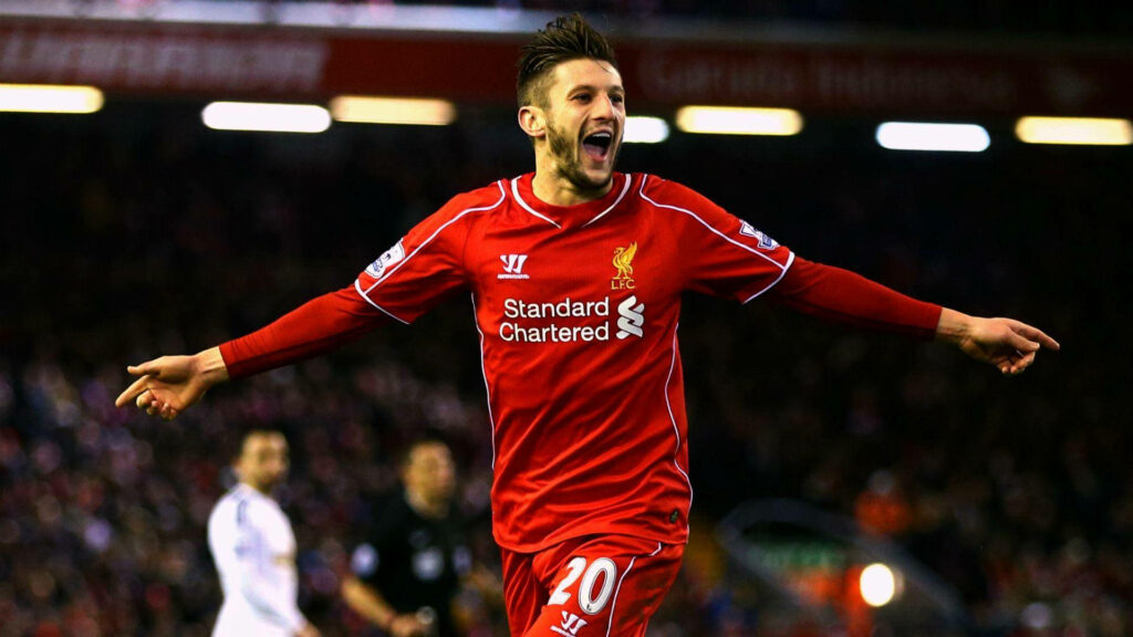 Adam Lallana in Liverpool jersey celebrating with arms wide on football field wallpaper background