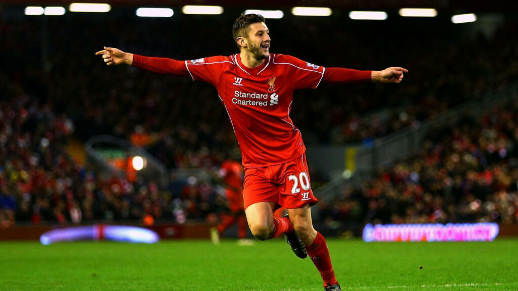 Adam Lallana celebrates a memorable football moment in Liverpool kit on the field wallpaper background