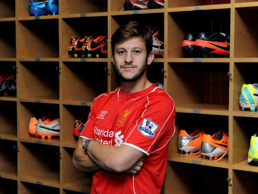 Adam Lallana in Liverpool FC kit standing by football boots and lockers team key player wallpaper