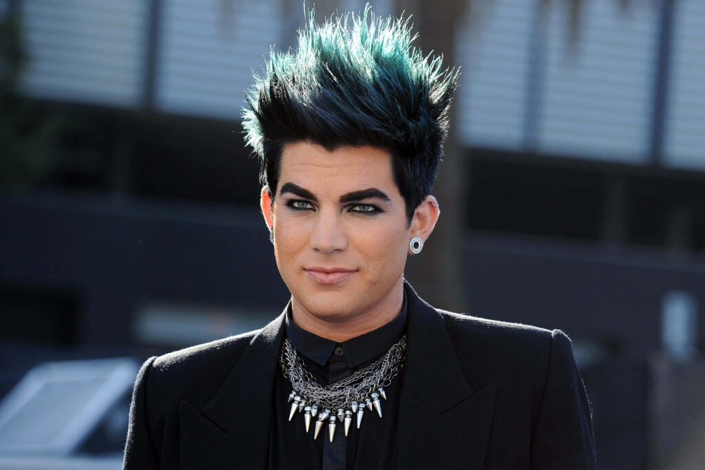 Adam Lambert portrait with bold hairstyle dramatic eye makeup and statement necklace wallpaper background
