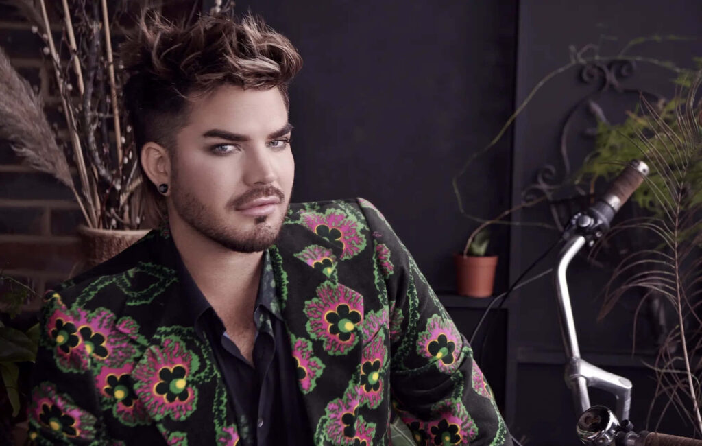 Adam Lambert vibrant floral blazer styled hair modern indoor setting bold expressive personality wallpaper