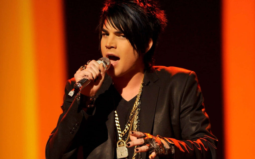 Adam Lambert energetic stage performance black jacket bold accessories dramatic lighting wallpaper