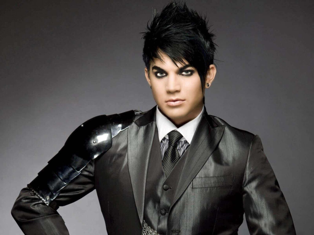 Adam Lambert wallpaper sharp suit metallic shoulder piece dramatic makeup spiked hairstyle dark background