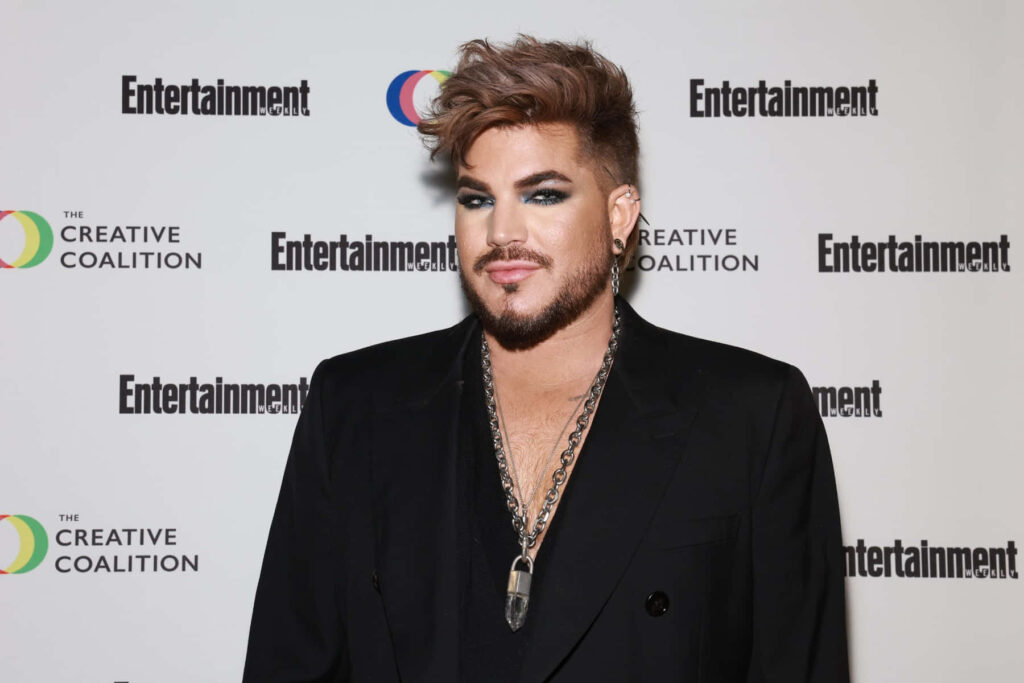 Adam Lambert in stylish black outfit with Entertainment Weekly and Creative Coalition logos background Wallpaper