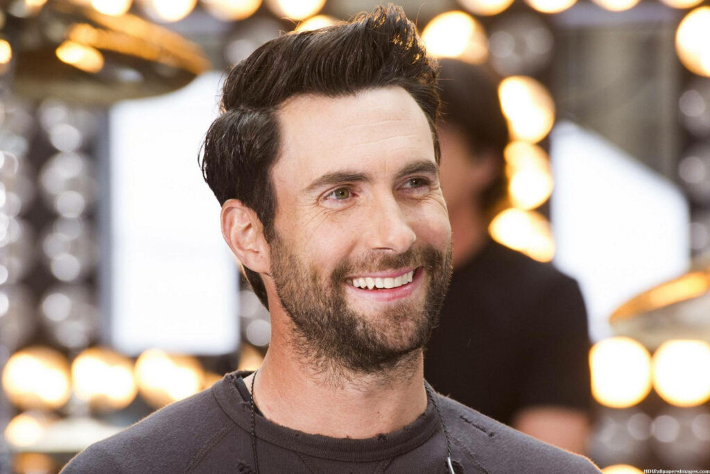 Bright Adam Levine smile wallpaper radiating charm and positivity for fans and stylish screens.