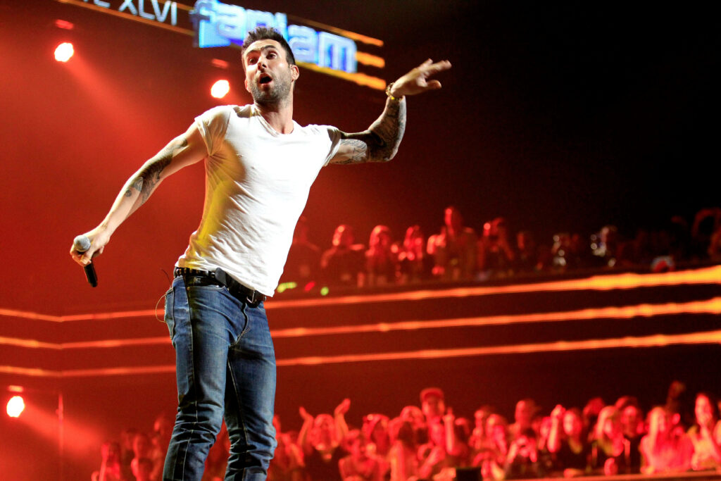 Adam Levine performing live, vibrant concert wallpaper with dynamic crowd and radiant lights.