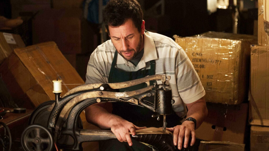 Adam Sandler focused crafting shoes surrounded by materials shoemaker film scene wallpaper background