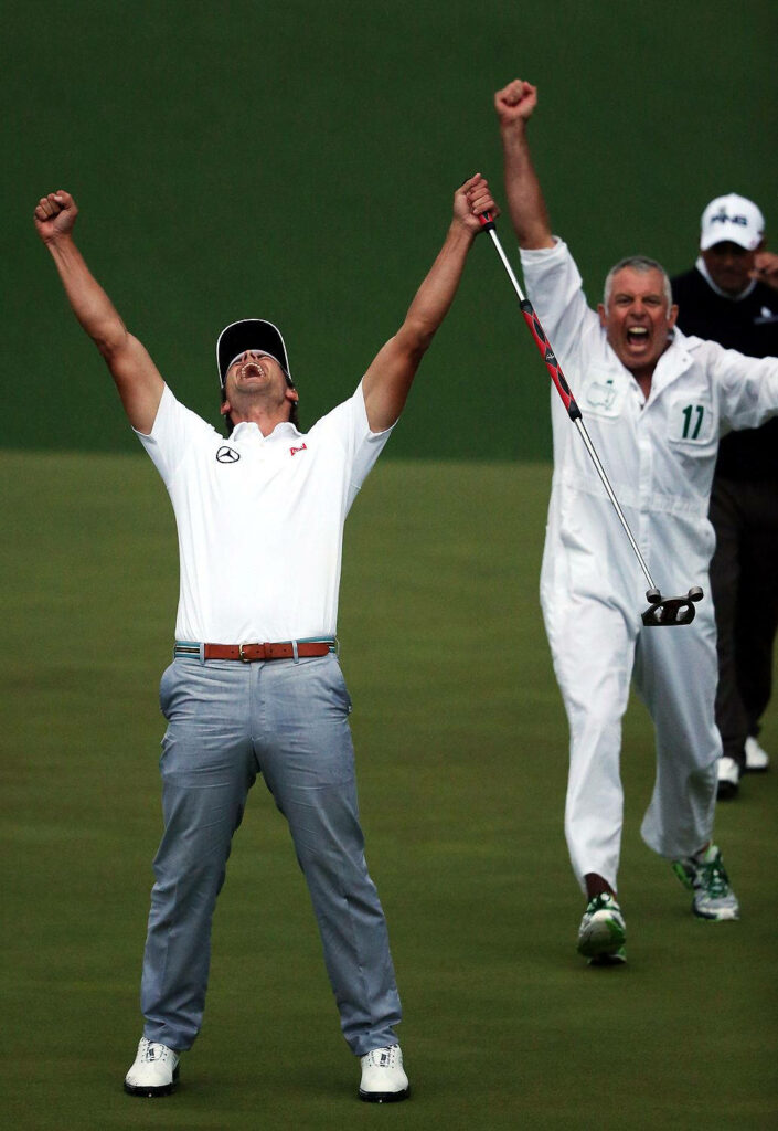 Adam Scott raises arms celebrating golf victory with caddie cheering on golf course wallpaper background