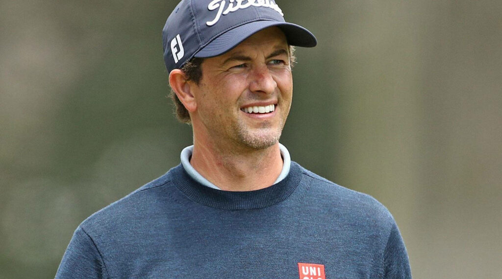 Adam Scott smiling on golf course wearing cap and blue sweater focused during game wallpaper