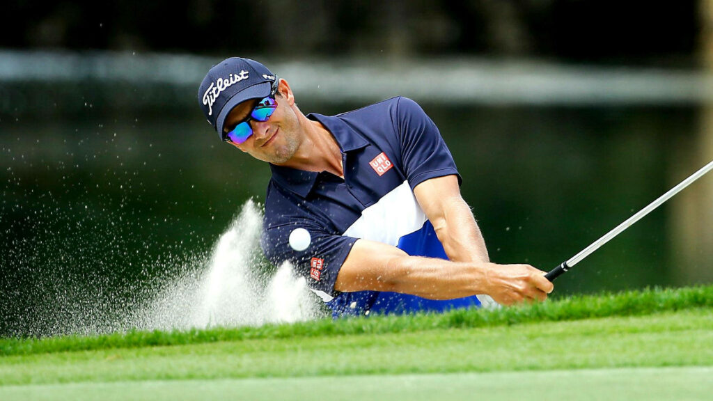 Adam Scott hitting powerful golf shot from sand bunker showing professional golf precision Wallpaper