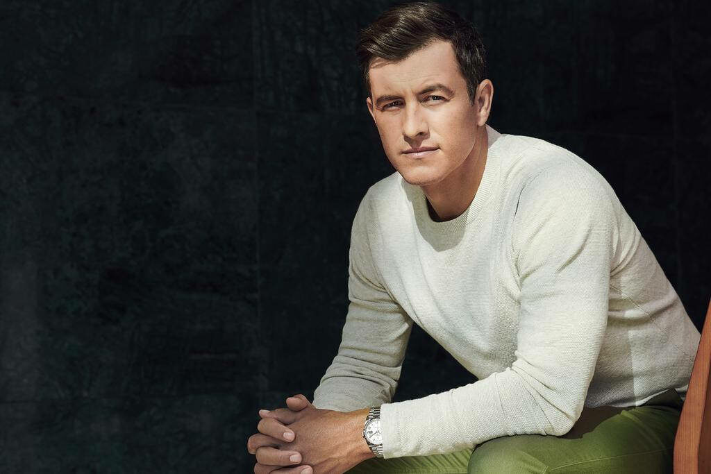 Adam Scott sharp confident in light sweater olive green pants dark background wallpaper