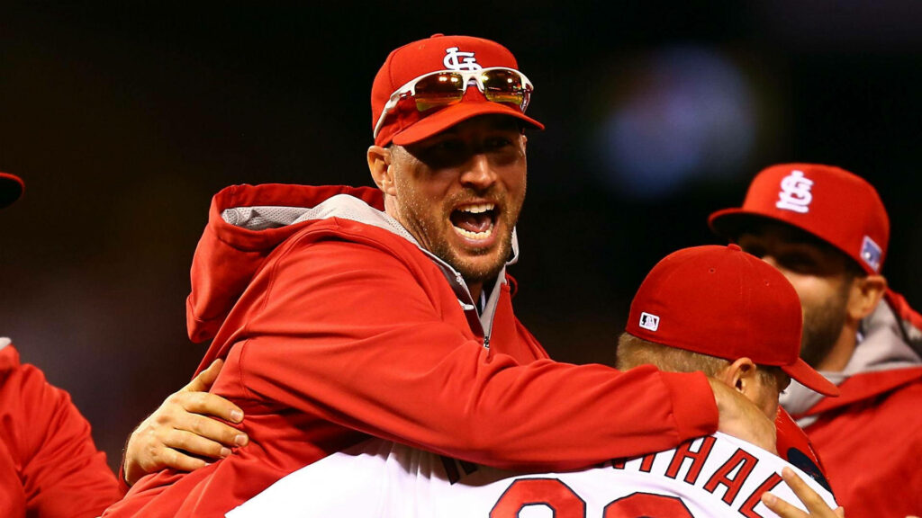 Adam Wainwright celebrating with teammates in red jacket on baseball field joyful moment wallpaper