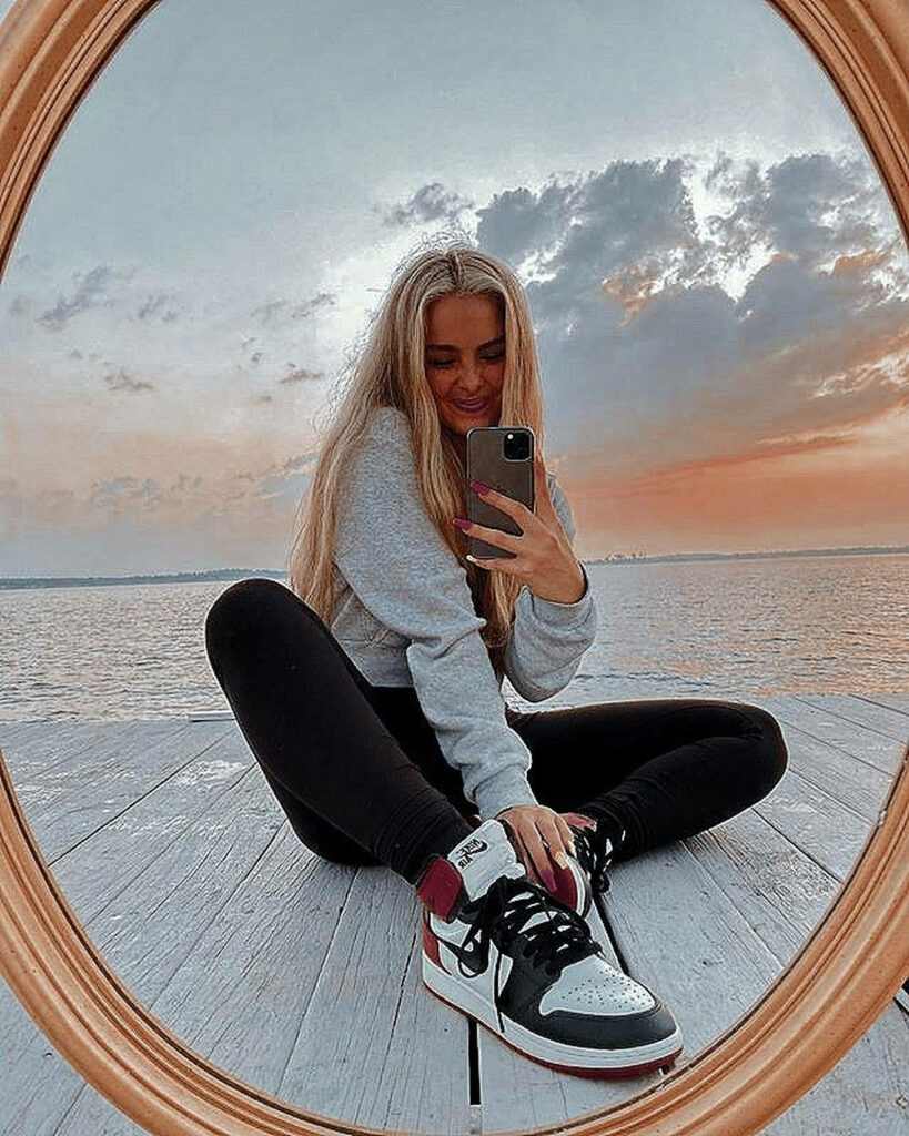 Addison Rae Sunset Mirror Selfie on Dock - Serene Wallpaper Background
