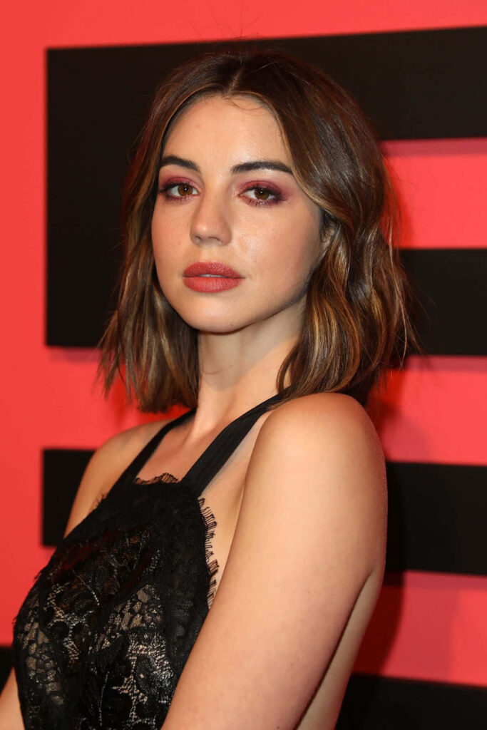 Adelaide Kane in black lace outfit with smoky eyes against bold red backdrop portrait wallpaper