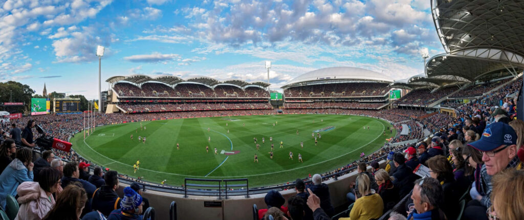 Panoramic view of Adelaide Oval during Australian Rules Football match with crowd and players Wallpaper