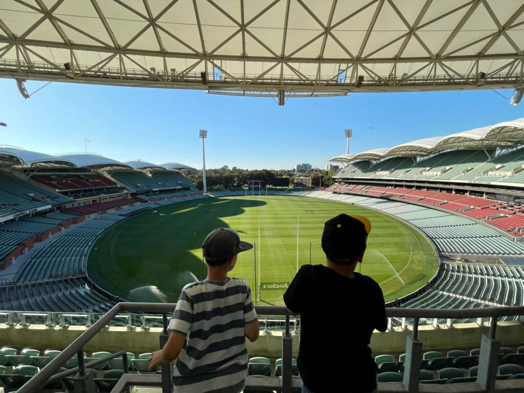 Adelaide Oval panoramic view with two spectators enjoying sunlit stadium architecture wallpaper