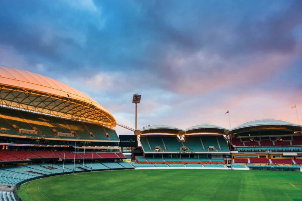 Adelaide Oval sunset view with modern stadium architecture and lush green field wallpaper background