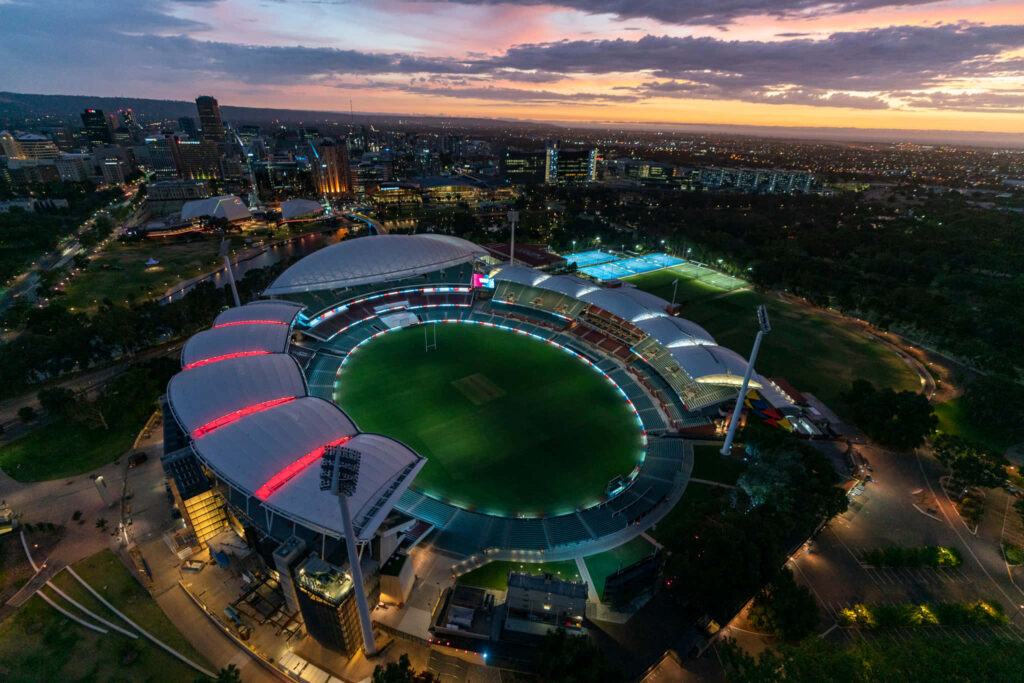 Aerial view of Adelaide Oval at twilight with vibrant cityscape and colorful sunset sky background Wallpaper