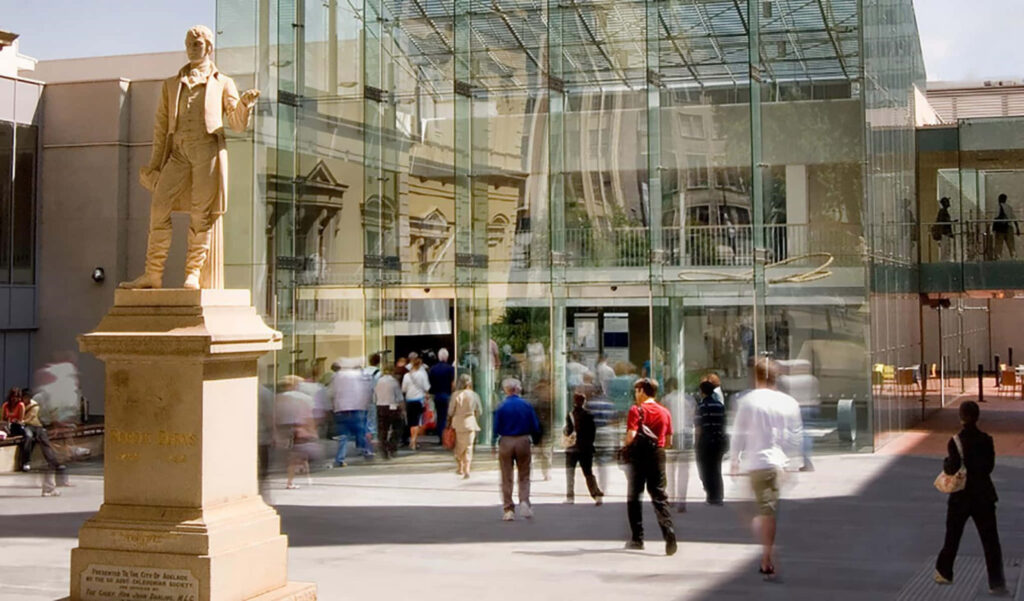 Adelaide State Library entrance with glass facade and welcoming statue background wallpaper