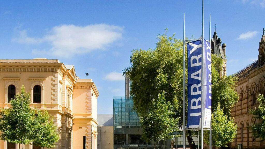 Adelaide State Library exterior with classic architecture and modern glass extension under blue sky Wallpaper