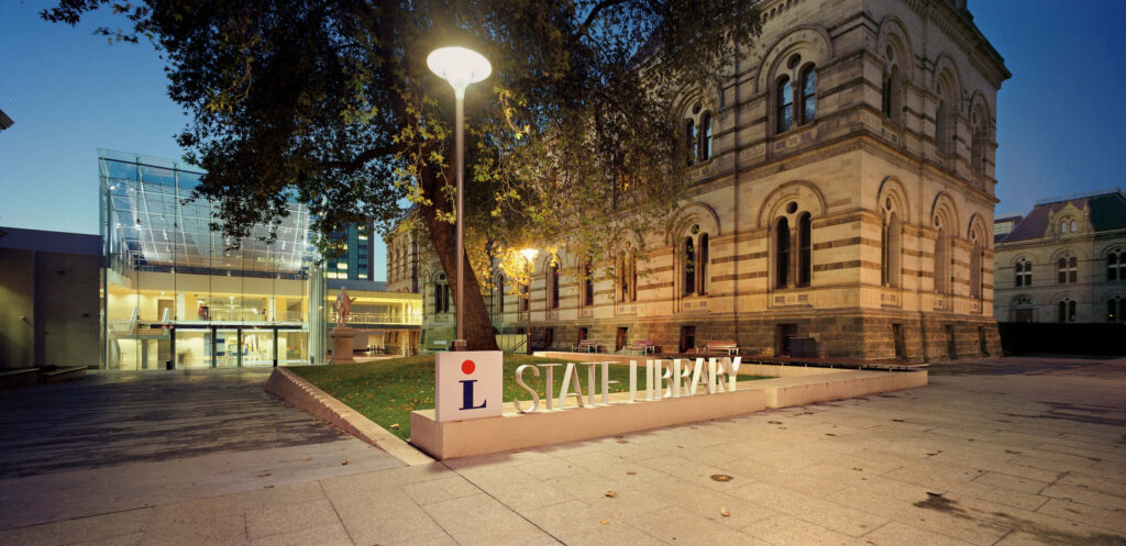 Adelaide State Library exterior at dusk historic architecture lit with modern glass entrance background Wallpaper