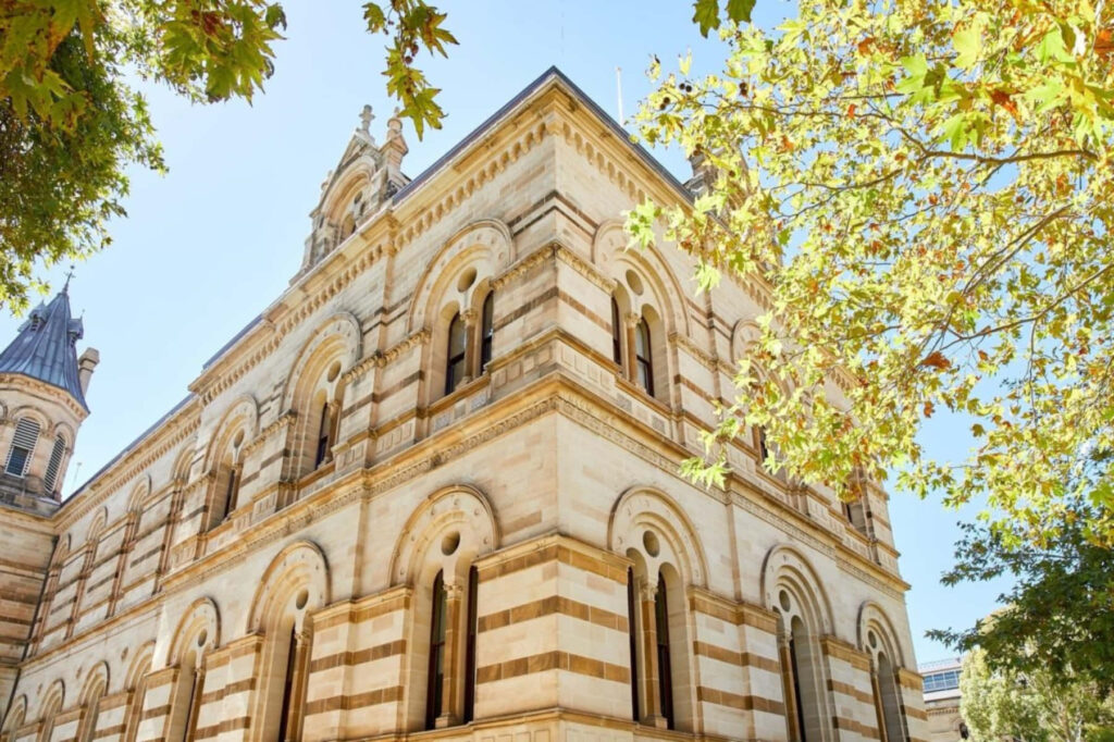 Adelaide State Library exterior with ornate stone arches green leaves and clear blue sky wallpaper
