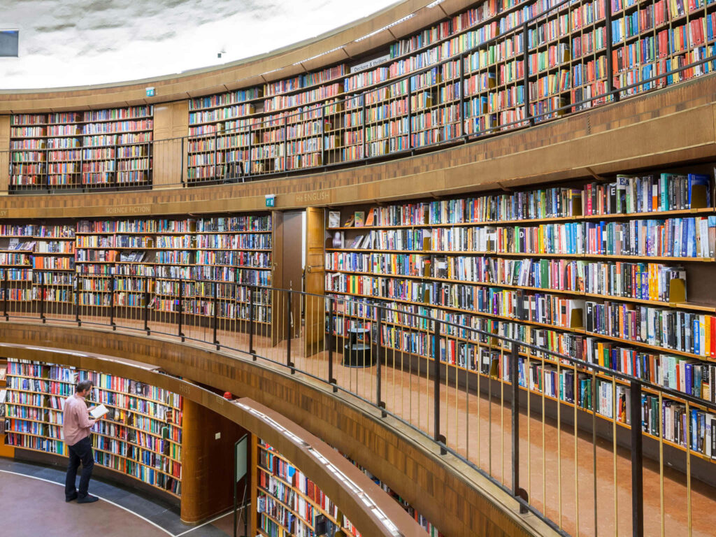 Adelaide State Library interior with curved balconies and shelves filled with many books Wallpaper