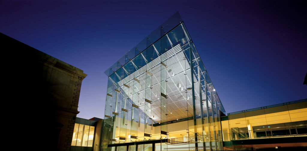Adelaide State Library modern glass facade illuminated at dusk architectural wallpaper background
