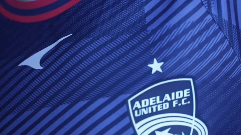Close up of Adelaide United FC jersey with team crest and bold blue kit design wallpaper background